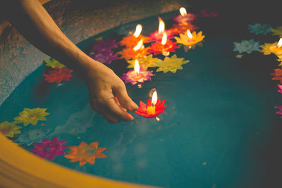 Woman keeping candles on water