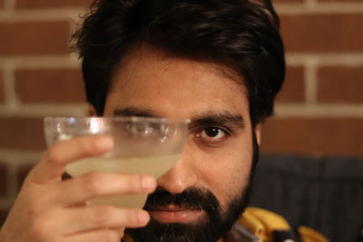 Close-up portrait of man holding drinking glass