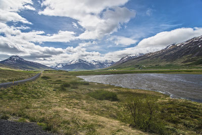 Scenic view of lake and mountains against cloudy sky