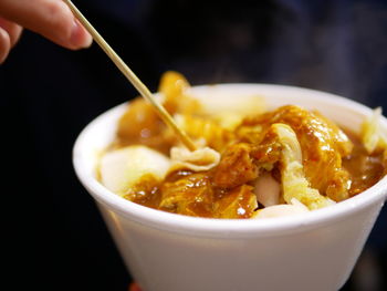 Close-up of hand holding soup in bowl