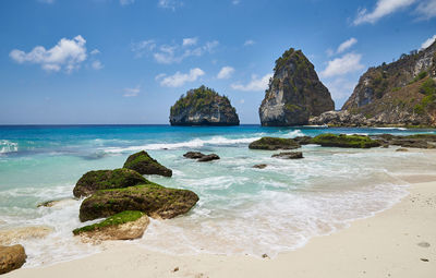 Scenic view of rocks in sea against sky