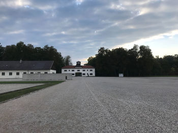 Empty road by building against sky