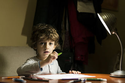 Portrait of boy drawing on paper