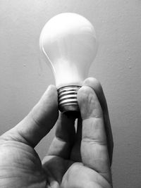 Close-up of hand holding light bulb