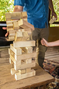 Low section of man standing on wooden table