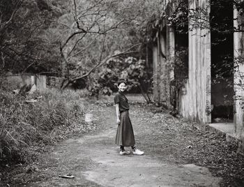 Full length of woman standing on tree trunk