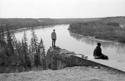 Rear view of man sitting in river
