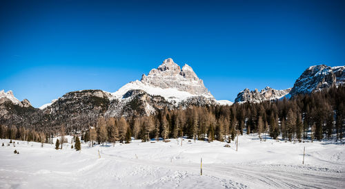 Panoramic view of snow covered mountain against blue sky