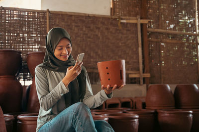 Portrait of young woman sitting on chair at home