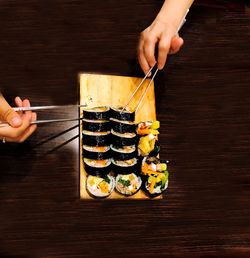 Midsection of man holding sushi