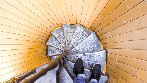 Low section view of person standing on spiral staircase