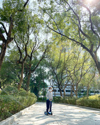 Full length of boy standing on footpath in park