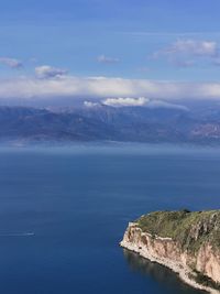 Scenic view of sea and mountains against blue sky