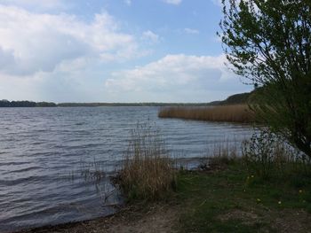 Scenic view of lake against cloudy sky