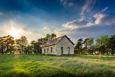 Houses on grassy field against sky