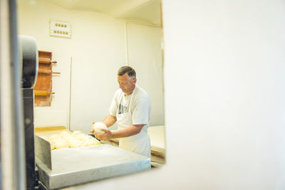 Balkan man shaping dough at a pasta shop in belgrade, serbia