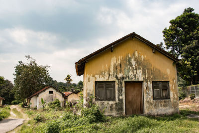 Abandoned house on field against sky