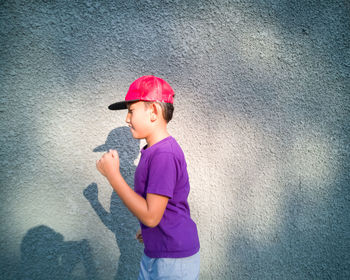 Boy running against concrete wall