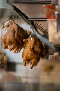 Close-up of roasted meat hanging on barbecue grill