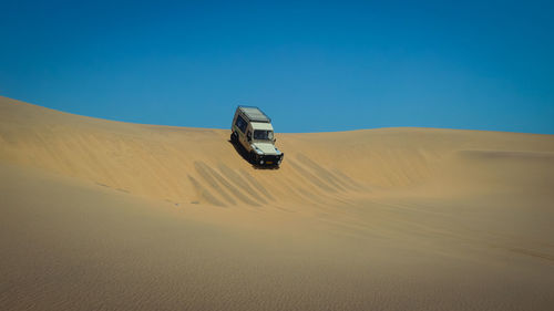 Scenic view of desert against clear blue sky