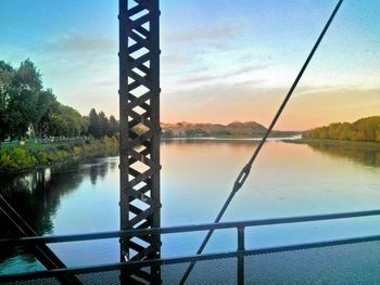 Bridge over river against cloudy sky