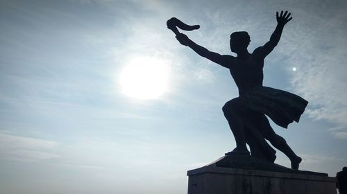 Low angle view of silhouette statue against sky