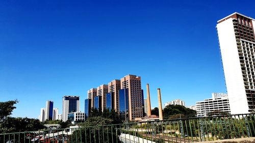 Modern buildings against clear blue sky