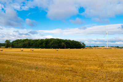 Scenic view of field against cloudy sky