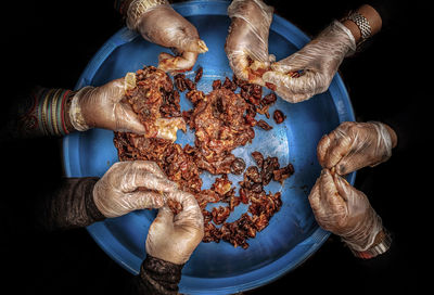 United hands of emirati ladies making a dates jam by pulling the dates fruits,.
