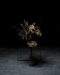 Flower vase on table against black background