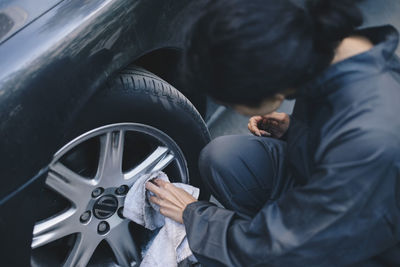 Rear view of man holding black car