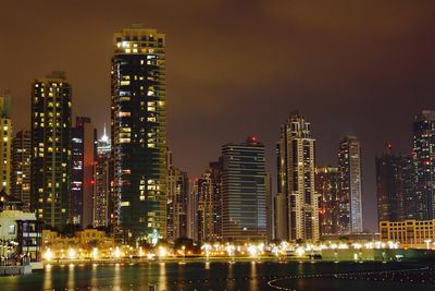 Illuminated buildings against sky at night