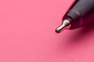 Close-up of red colored pencils against pink background