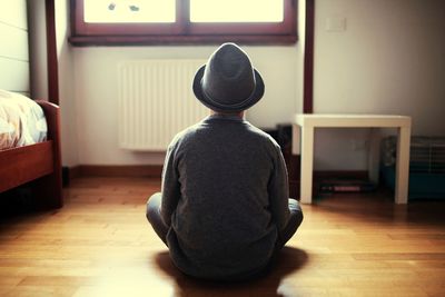 Rear view of man sitting at home