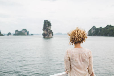 Rear view of woman looking at sea against sky