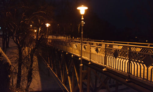 Illuminated bridge against sky at night