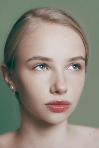 Young blonde model posing on green, sensual portrait