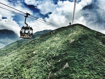 Low angle view of overhead cable car against sky