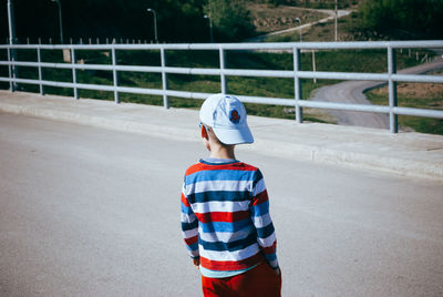 Rear view of boy standing on road