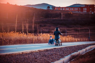 Rear view of people riding motorcycle on road