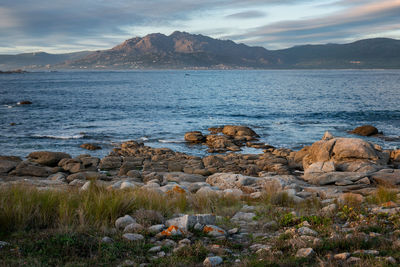 Scenic view of sea and mountains against sky