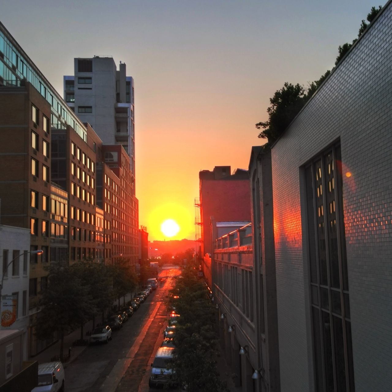 building exterior, architecture, sunset, built structure, transportation, city, car, sun, street, road, orange color, the way forward, sunlight, land vehicle, mode of transport, sky, city life, building, diminishing perspective, city street