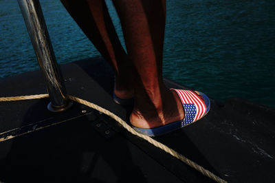 Low section of person standing on boat in sea