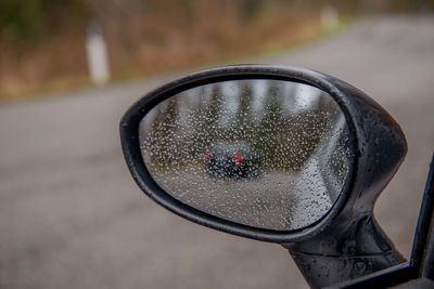 Close-up of wet side-view mirror