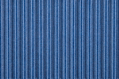 Background made of blue corrugated cardboard with vertical stripes, view from above.