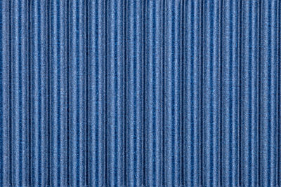 Background made of blue corrugated cardboard with vertical stripes, view from above.