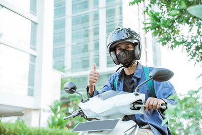 Side view of man riding motorcycle on street