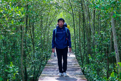 Portrait of man standing on footpath in forest