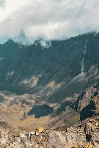 A hiker in the panoramic mountain landscapes of rwenzori mountains 
