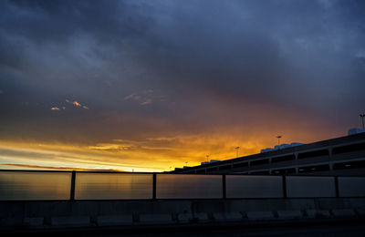 Silhouette pier over sea against sky during sunset